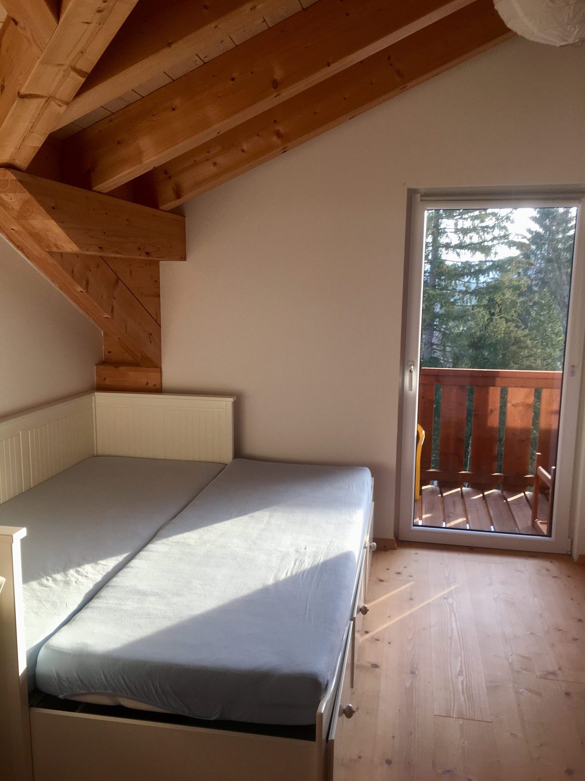 Schlafzimmer zwei mit Bett und offener Balkontür